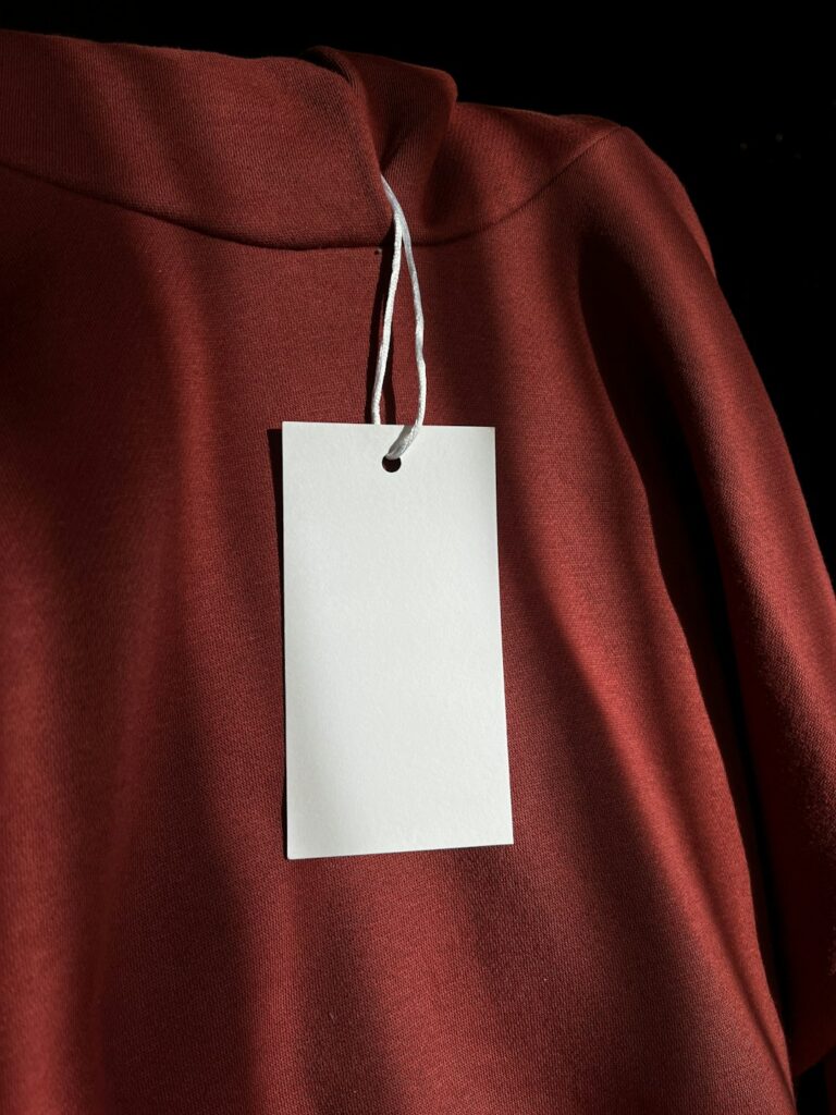 a red sweatshirt with a white tag attached to it
