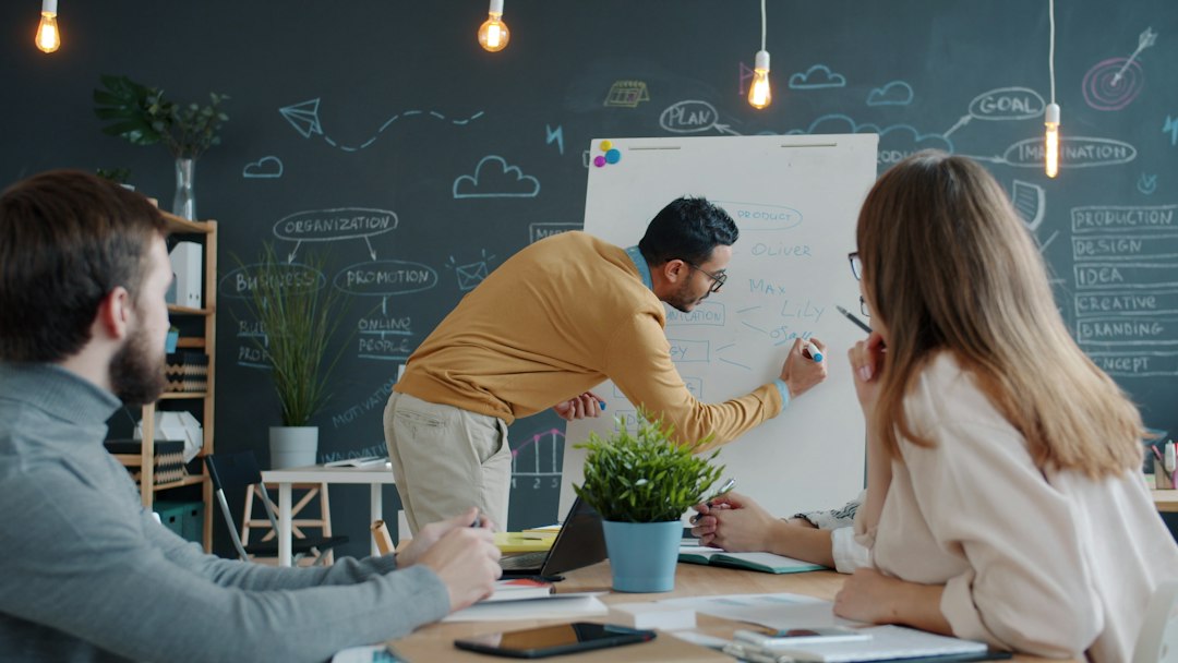 Man presenting ideas on whiteboard to colleagues