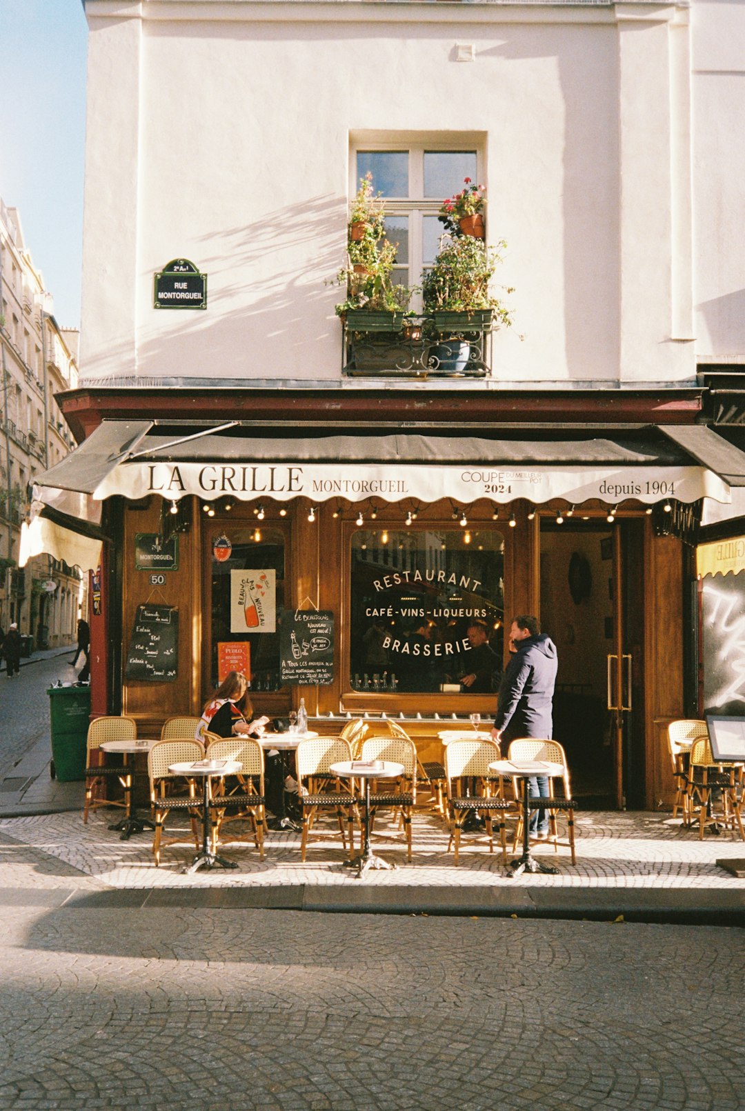 People sit at tables outside a parisian restaurant