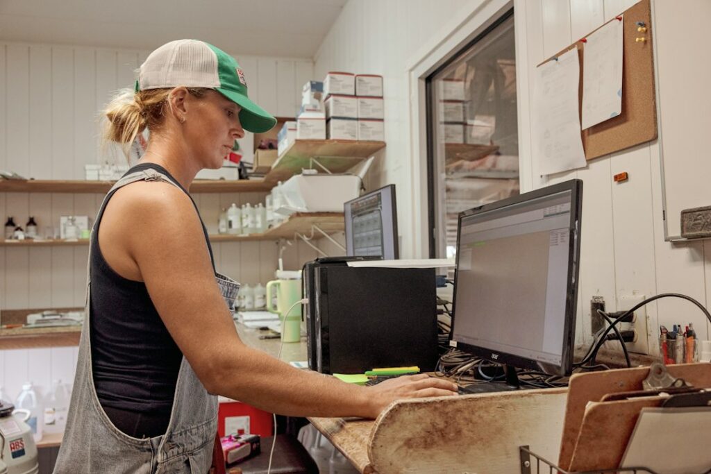 Woman typing at a farm office computer